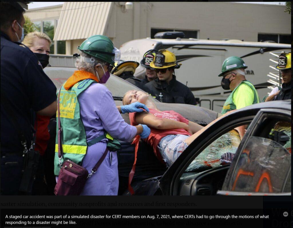 A person acts as a victim in a car while CERT volunteers stage a rescue during the 2021 CERT Expo.